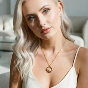 Woman wearing a necklace with a pendant in a neutral setting